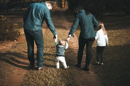Family Walking Together Down Dirt Road
